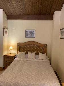 a bedroom with a large bed and a wooden ceiling at Apartamentos Valdelinares in Valdelinares