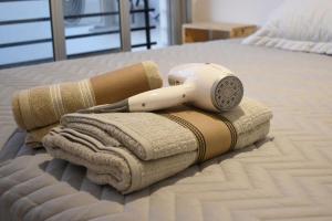 um secador de cabelo numa pilha de toalhas numa cama em Palermo Soho. Moderno, Cómodo y Luminoso em Buenos Aires