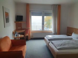 a hotel room with two beds and a desk and a window at Hotel-Gasthof zum Ritter in Haßmersheim