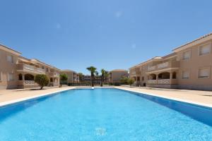 una piscina frente a algunos edificios de apartamentos en LUCKY HOLIDAY RiUMAR, en Riumar