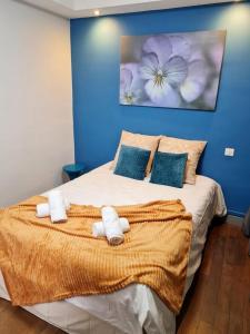um quarto azul com uma cama com toalhas em Le Citadin chic em Dreux