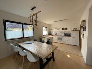 cocina y comedor con mesa de madera y sillas en Ferienhaus Seenliebe, en Senftenberg