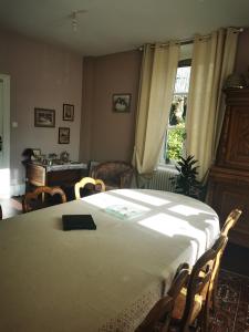 a bedroom with a bed and a table and chairs at Le Clos de la Borde, chambre verte in Arches