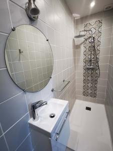 a bathroom with a sink and a mirror and a shower at Le Clos de la Borde, chambre verte in Arches