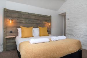 ein Schlafzimmer mit einem großen Bett mit gelben Kissen in der Unterkunft The Cowshed in Bryn-crug