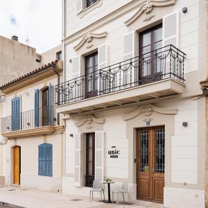 - un bâtiment blanc avec une porte en bois et un balcon dans l'établissement Unic - Turisme d'interior, à Andratx