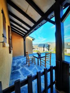 a patio with a table and chairs and a view at Maison des Isard in Saint-Pierre-dels-Forcats