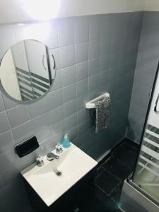 y baño con lavabo blanco y espejo. en Apartamento Billinghurts Excelente Ubicacion en Buenos Aires