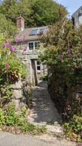 a stone house with purple flowers in front of it at The Hideaway in Falmouth