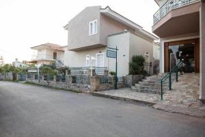 a house with stairs leading to the front of it at Remvi Hotel - Apartments in Stoupa