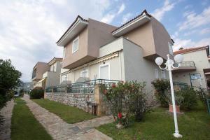 a large house with a fence and a street light at Remvi Hotel - Apartments in Stoupa