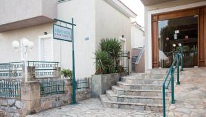 a sign in front of a building with stairs at Remvi Hotel - Apartments in Stoupa