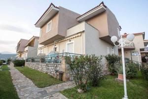 a large house with a stone wall and a street light at Remvi Hotel - Apartments in Stoupa