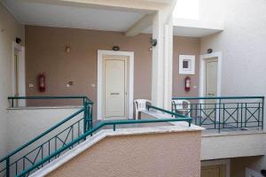 a hallway of a building with a white door at Remvi Hotel - Apartments in Stoupa