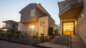 a building with a staircase in front of a building at Remvi Hotel - Apartments in Stoupa