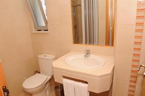 a bathroom with a sink and a toilet and a mirror at Albufeira Mar Vilas in Albufeira +9 photos