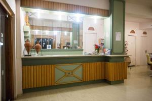 a restaurant with a counter with a mirror at Remvi Hotel - Apartments in Stoupa