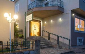 a building with a staircase and a sign in front of it at Remvi Hotel - Apartments in Stoupa