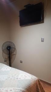 een kamer met een bed, een ventilator en een muur bij T'ika Wasi in San Pedro de Atacama