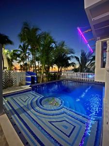 a swimming pool at night with palm trees at Sunset Paradise in San Andrés