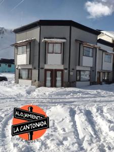 un cartel en la nieve frente a una casa en La Cantonada, alojamiento turístico, Caviahue en Caviahue