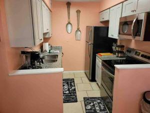 a kitchen with white cabinets and a black refrigerator at Elegant 2-bedroom pet-friendly villa w 2 parking spaces in Hilton Head Island
