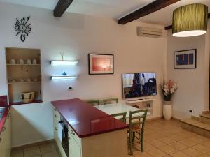 a kitchen and living room with a table and a tv at Giulia House via dell Ariento 5 Firenze in Florence