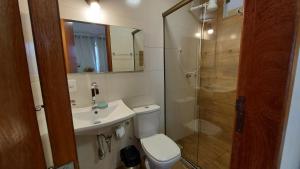 a bathroom with a toilet and a sink and a shower at Recanto dos Ipês Pousada in Divisa +168 photos