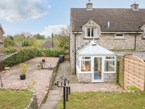 a greenhouse on the side of a house at Cloud View Cottage in Ashbourne