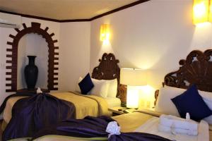 a hotel room with two beds and a mirror at Ecotel Quinta Regia in Valladolid