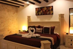 a bedroom with a bed with a towel on it at Ecotel Quinta Regia in Valladolid