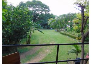 uma vista para um parque a partir de uma varanda em Hostal Villas Mexico em San Juan del Sur