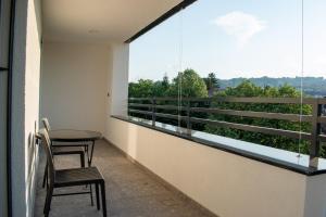 a balcony with a table and chairs and a large window at Premium Apartmani Banja Luka in Banja Luka