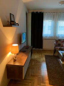 - un salon avec un bureau et un ordinateur dans l'établissement Apartman Manja, à Lukavica