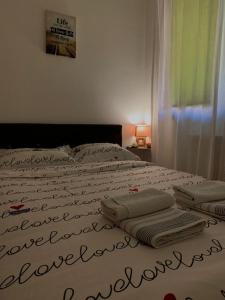 - un lit avec des serviettes dans une chambre dans l'établissement Apartman Manja, à Lukavica
