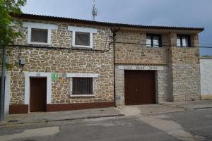 un antiguo edificio de piedra con dos puertas en una calle en Habitación independiente II en Casa Rural Javier, en Valmuel