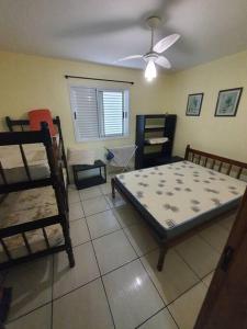 um quarto com uma cama e beliches em Espaçoso e Agradável - para 23 pessoas - WI FI em Balneário Praia do Leste