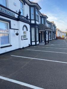 um parque de estacionamento vazio em frente a um edifício em Burlington Hotel em Sandown