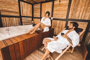 a man and a woman sitting in chairs in a bath tub at Cardinal Glamping in Guatapé