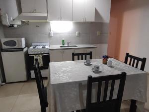 a kitchen with a table and chairs and a kitchen with white cabinets at DEPARTAMENTO EN COMPLEJO RESIDENCIAL in Godoy Cruz