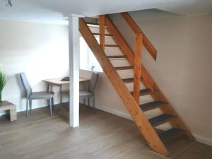 a wooden staircase in a room with a table and chairs at Apartment in Saxony in a charming area in Freital