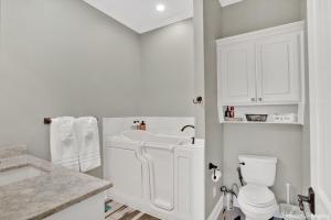 La salle de bains blanche est pourvue d'un lavabo et de toilettes. dans l'établissement The Cross Lake Maison, à Shreveport