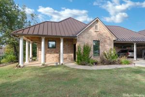 a brick house with a metal roof at The Cross Lake Maison in Shreveport