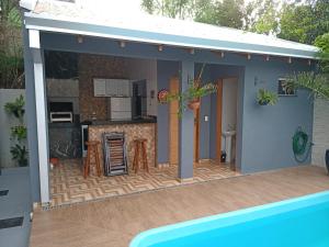 a small house with a kitchen and a swimming pool at Casa Temporada Aconchego e tranquilidade 1 in Bonito