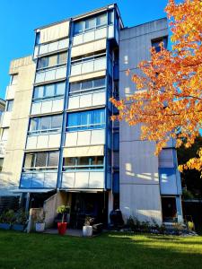 un edificio de oficinas con un árbol delante de él en Appartement avec terrasse, en Sion