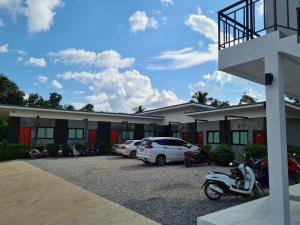 ein Hotel mit Autos auf einem Parkplatz in der Unterkunft Vamin Resort Chiangkhan Loei วามินทร์รีสอร์ท เชียงคาน เลย in Chiang Khan