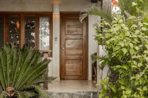 una puerta delantera de madera de una casa con plantas en Playa Venao Hotel Resort, en Playa Venao