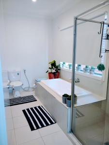 a bathroom with a glass shower and a toilet at Tarneit Treat in Tarneit