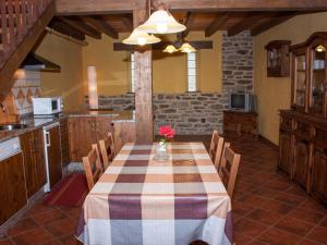 a kitchen with a table and chairs in a room at Casa rural El Trubio in Vigo de Sanabria
