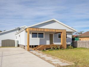 a white house with a porch and a driveway at Sienna by the Sea in Callala Beach